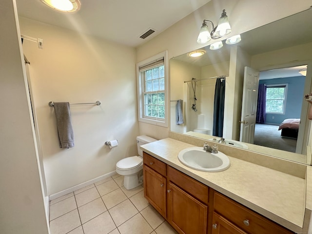 bathroom featuring walk in shower, vanity, toilet, and tile patterned flooring