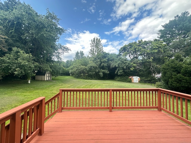 wooden terrace with a shed and a yard