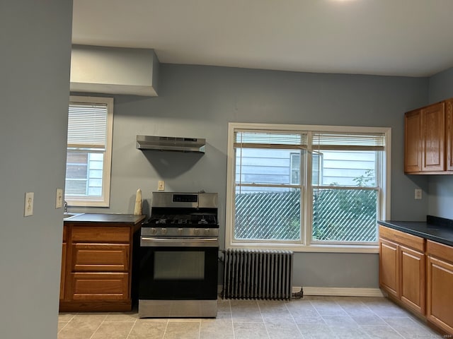 kitchen featuring radiator heating unit, extractor fan, and stainless steel gas range