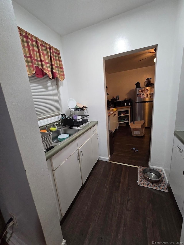 kitchen featuring ceiling fan, dark wood-type flooring, sink, white cabinets, and stainless steel refrigerator