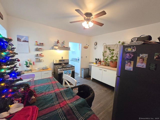 kitchen featuring white cabinetry, stainless steel range with gas cooktop, dark hardwood / wood-style floors, ventilation hood, and fridge