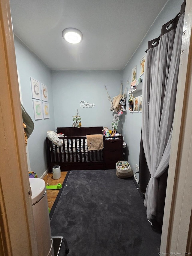 bedroom with carpet floors and a nursery area