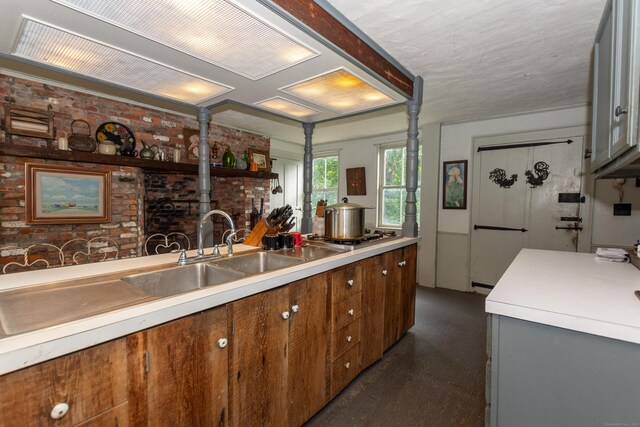 kitchen with stainless steel gas stovetop and brick wall