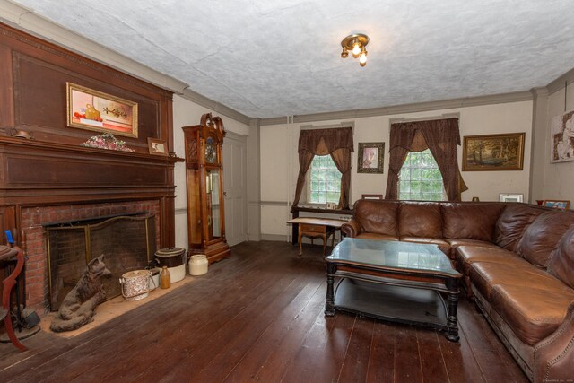 living room featuring a brick fireplace and dark wood-type flooring