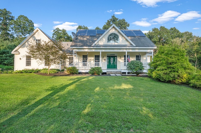 view of front of home with a front yard, solar panels, and a porch