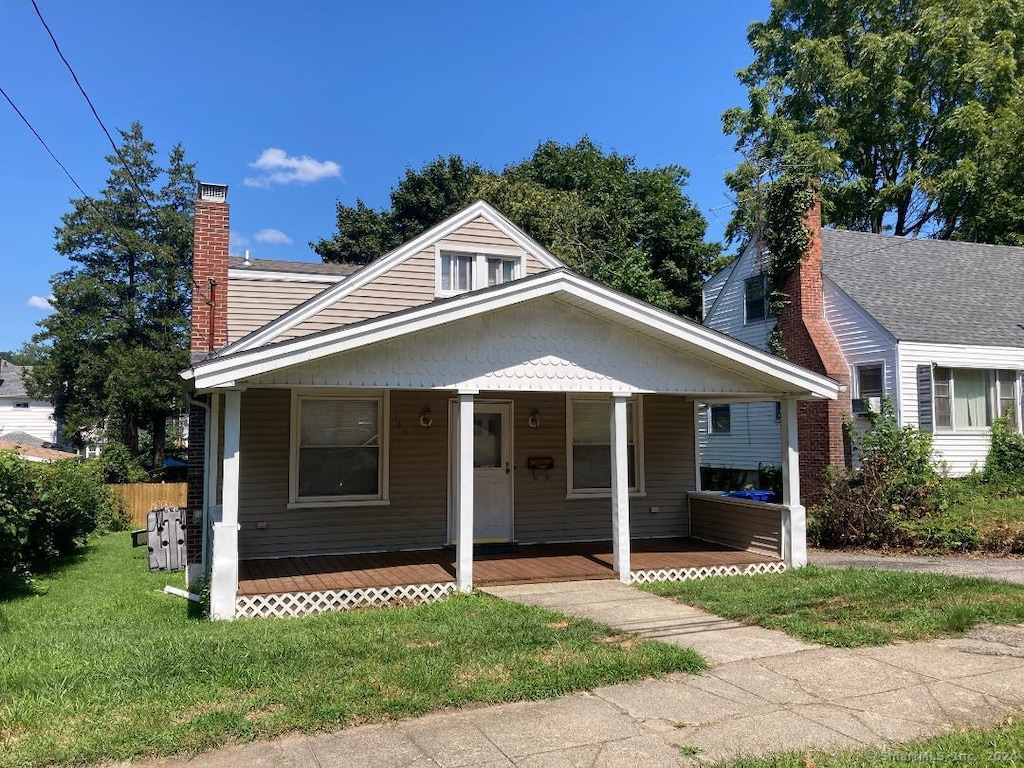 bungalow with a front lawn and covered porch