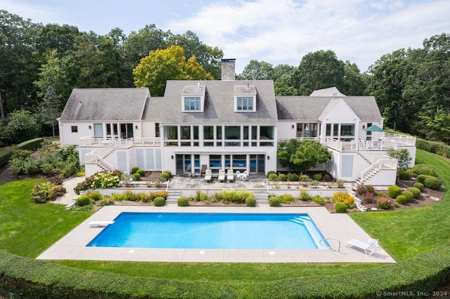 138 River Rd, Deep River, CT 06417 - back of house with stairs, a chimney, a patio area, a lawn, and an outdoor pool