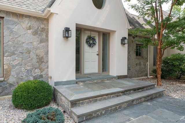 138 River Rd, Deep River, CT 06417 - doorway to property featuring stone siding and roof with shingles