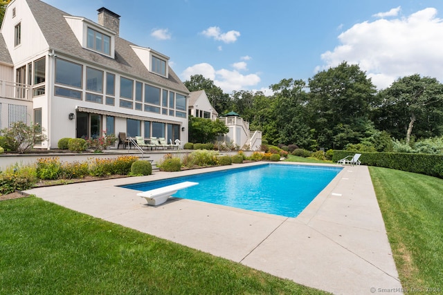 view of swimming pool with a patio, a yard, a diving board, and a sunroom