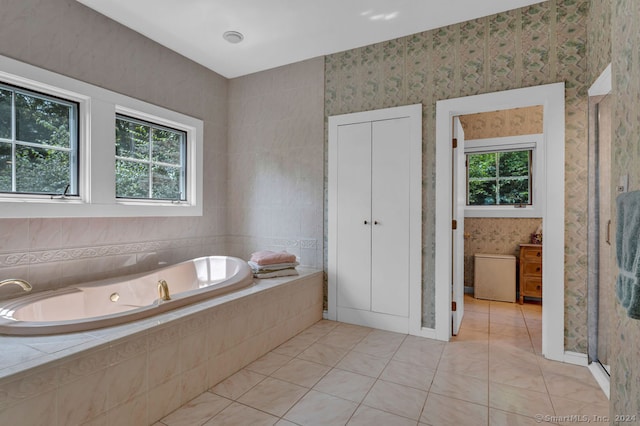 bathroom featuring tile patterned floors, tiled bath, and plenty of natural light