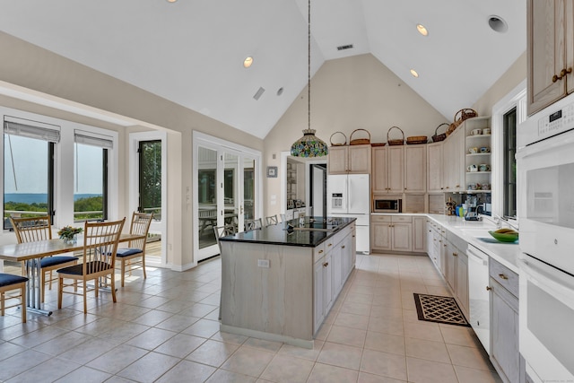 kitchen featuring light brown cabinets, high vaulted ceiling, a kitchen island, and white appliances