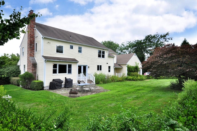 back of property with a patio area, a chimney, a fire pit, and a lawn