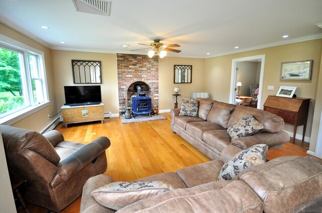 living room with light wood-style flooring, visible vents, and ornamental molding