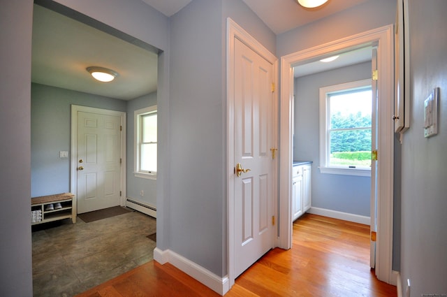 hallway featuring light wood-type flooring, baseboards, and baseboard heating