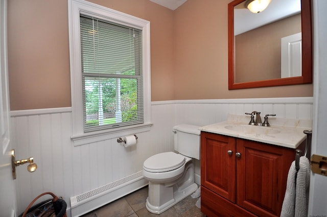 bathroom featuring toilet, a wainscoted wall, a baseboard heating unit, and vanity