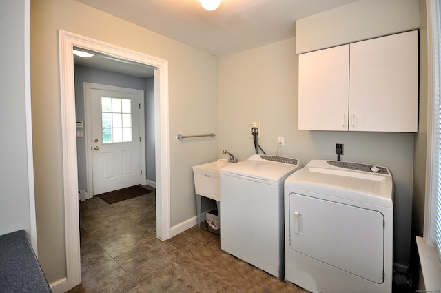 laundry area with a sink, washing machine and clothes dryer, cabinet space, and baseboards