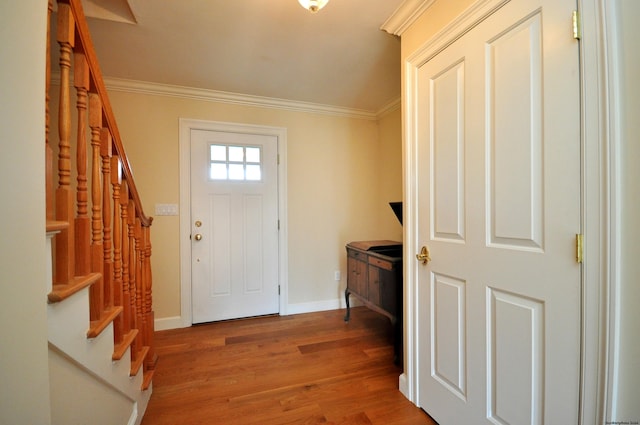 entrance foyer featuring stairs, crown molding, baseboards, and wood finished floors