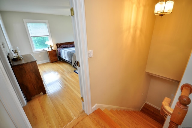 hallway featuring light wood finished floors and baseboards