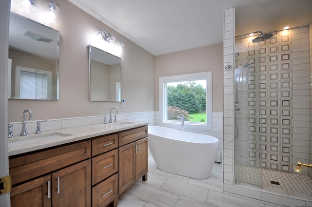 full bathroom featuring tile walls, visible vents, walk in shower, and a sink