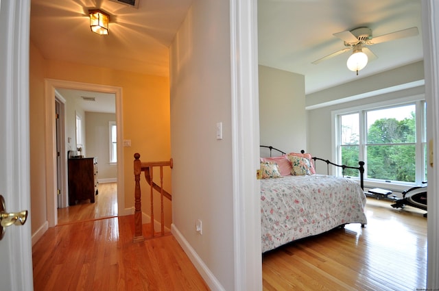 bedroom featuring light wood finished floors, visible vents, and baseboards