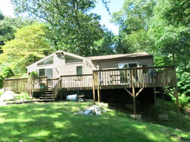 rear view of property with a lawn and a deck