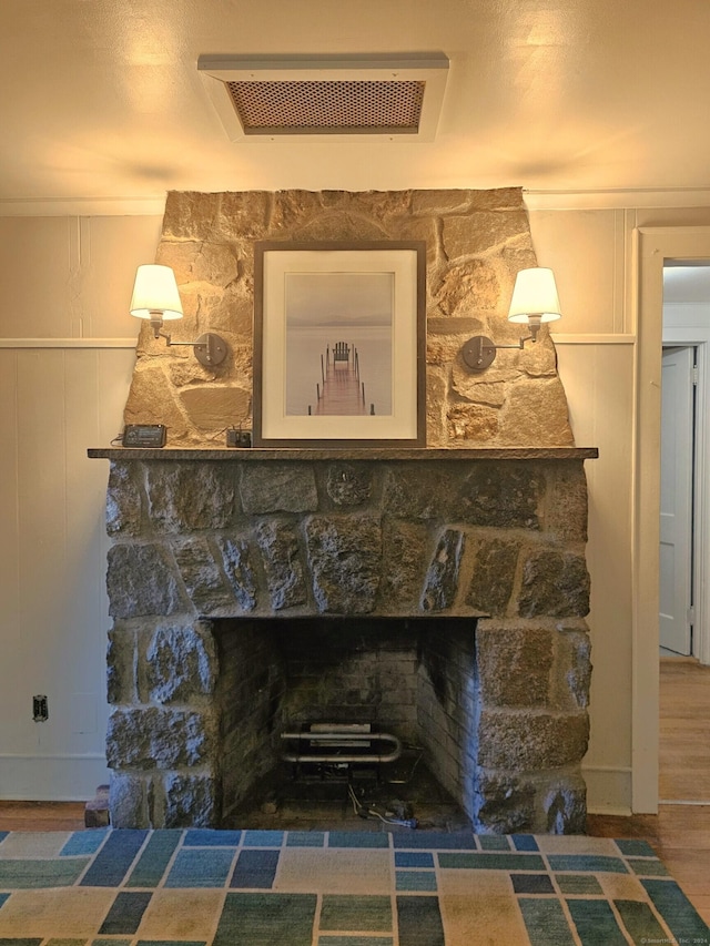 interior details with a stone fireplace and hardwood / wood-style floors