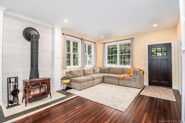 living room with crown molding, hardwood / wood-style floors, and a wood stove