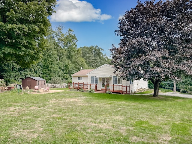 view of front of home with a front lawn, a wooden deck, and a shed