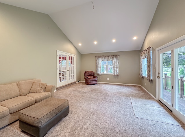 living room with high vaulted ceiling and light colored carpet