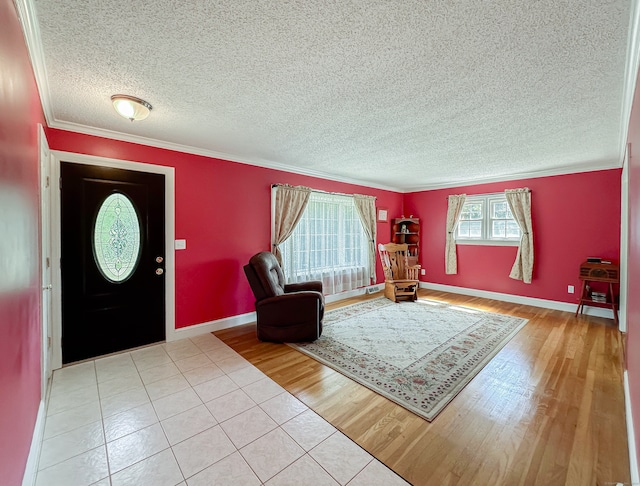 entrance foyer featuring a textured ceiling, crown molding, and light wood-type flooring