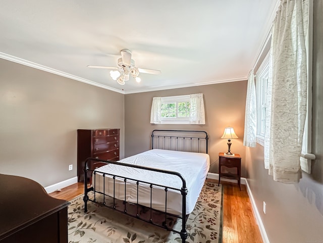 bedroom featuring ceiling fan, light hardwood / wood-style floors, and crown molding