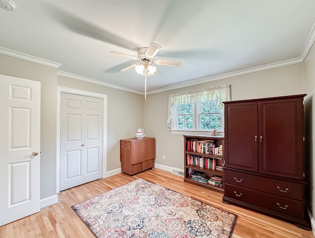 interior space with crown molding, light hardwood / wood-style flooring, ceiling fan, and a closet