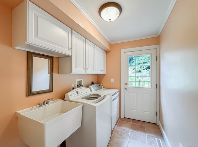 clothes washing area with crown molding, separate washer and dryer, cabinets, and sink