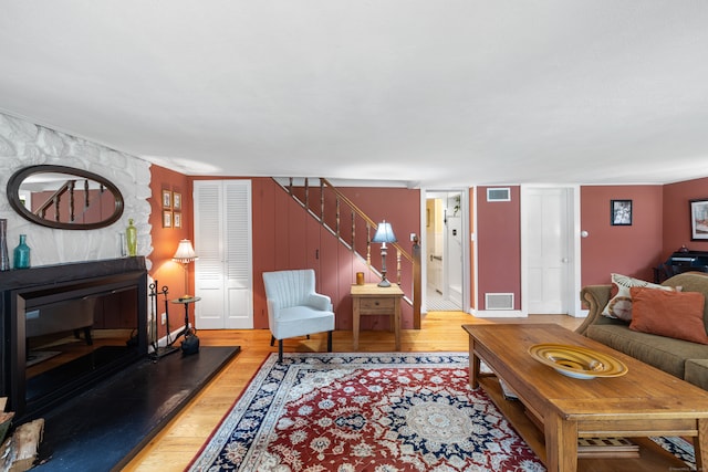 living room featuring light wood-type flooring and a fireplace