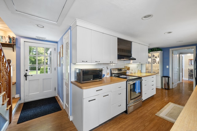 kitchen with white cabinetry, hardwood / wood-style flooring, backsplash, and stainless steel appliances