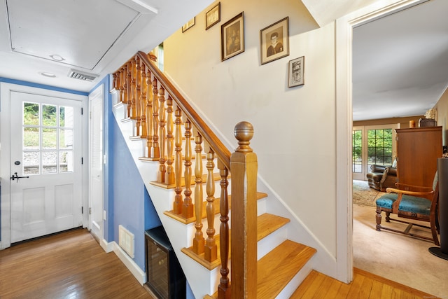 stairs with wood-type flooring and plenty of natural light