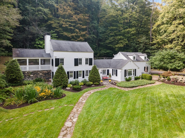 view of front facade featuring a sunroom and a front lawn