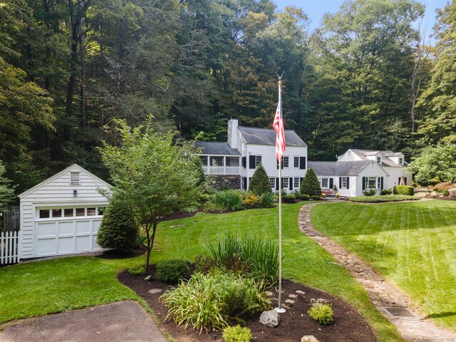 view of front of home featuring a front lawn, a garage, and an outdoor structure