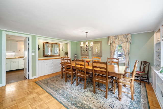 dining room featuring light parquet flooring, an inviting chandelier, and crown molding