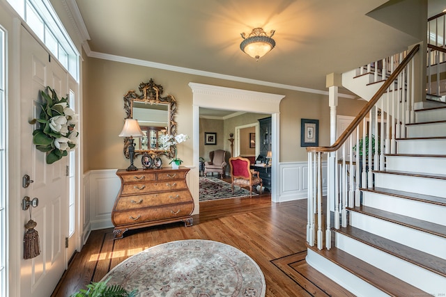 entryway with ornamental molding and dark hardwood / wood-style flooring