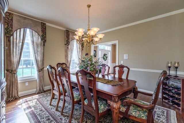 dining area featuring ornamental molding, a notable chandelier, and hardwood / wood-style floors