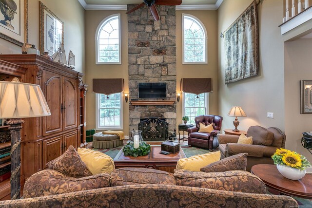 living room featuring ornamental molding, a fireplace, and ceiling fan