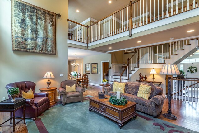 living room featuring hardwood / wood-style flooring, a chandelier, and a high ceiling