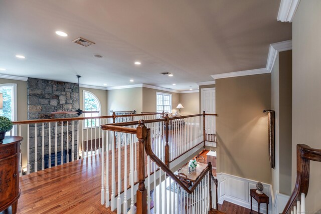 stairs with ornamental molding, wood-type flooring, and plenty of natural light