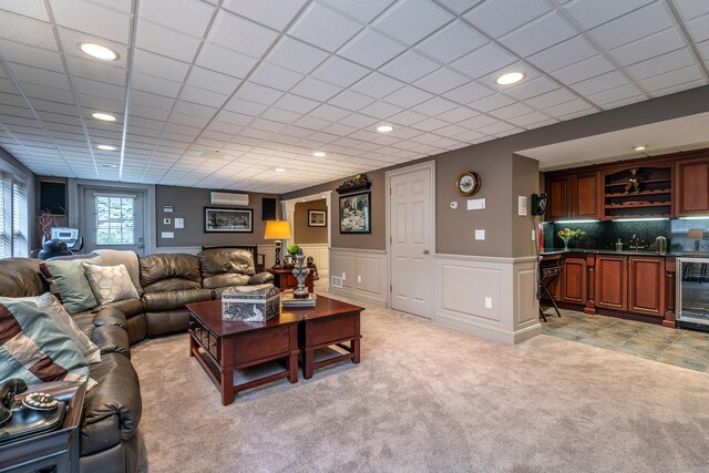 carpeted living room with wet bar and beverage cooler