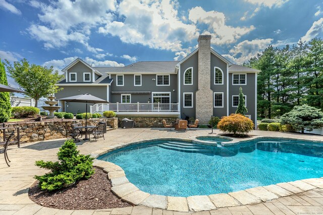 view of pool featuring a patio and an in ground hot tub