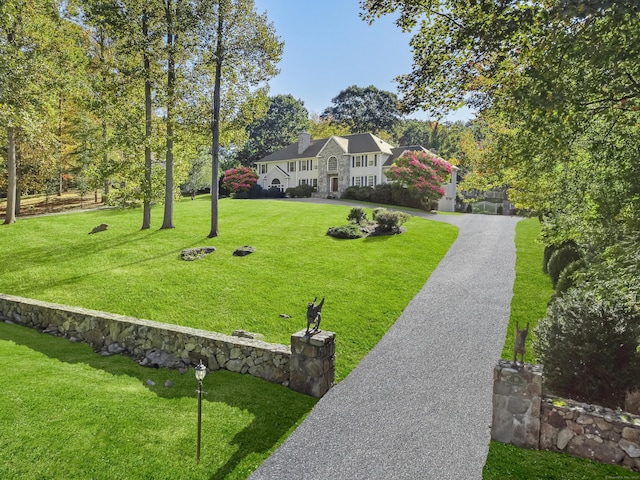 view of front of house with decorative driveway and a front lawn