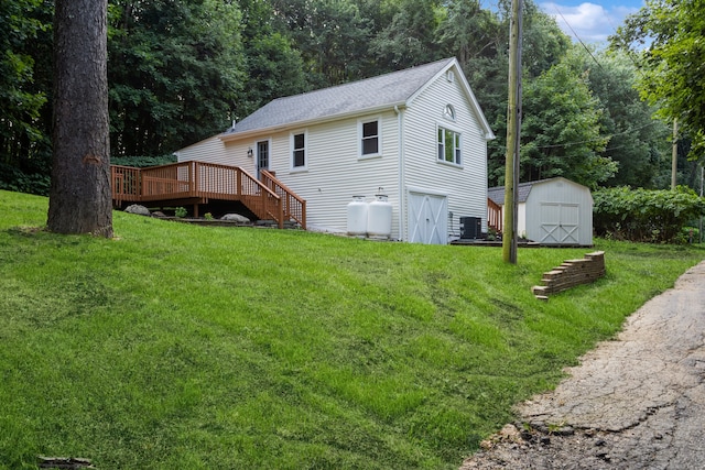 view of side of home featuring a lawn, a storage shed, central AC unit, and a deck