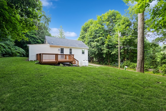 back of property with a yard and a wooden deck