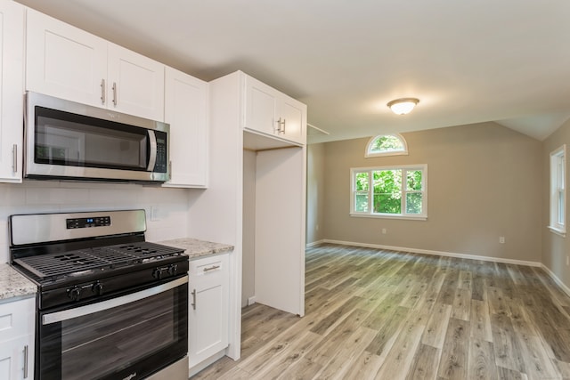 kitchen featuring white cabinetry, stainless steel appliances, light hardwood / wood-style flooring, and light stone counters